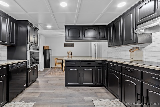 kitchen with light hardwood / wood-style floors, black appliances, tasteful backsplash, and light stone counters