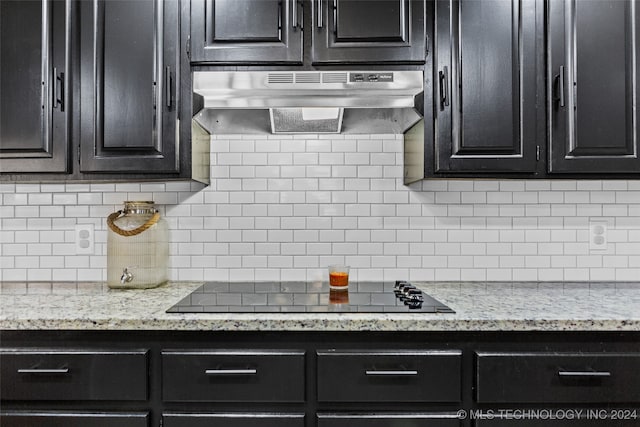 kitchen featuring range hood, backsplash, light stone countertops, and black electric stovetop