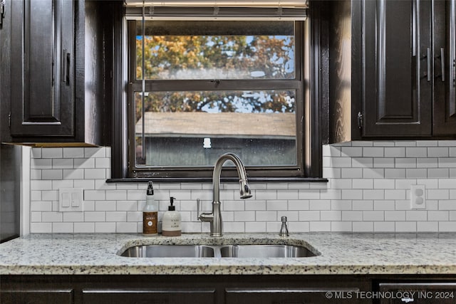 kitchen with sink, decorative backsplash, and light stone counters