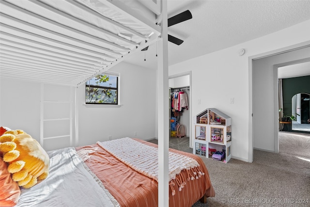 carpeted bedroom featuring ceiling fan and a closet