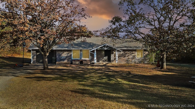 ranch-style home featuring a lawn