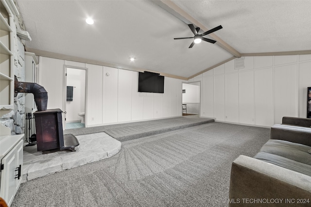 carpeted living room with a textured ceiling, lofted ceiling with beams, and ceiling fan