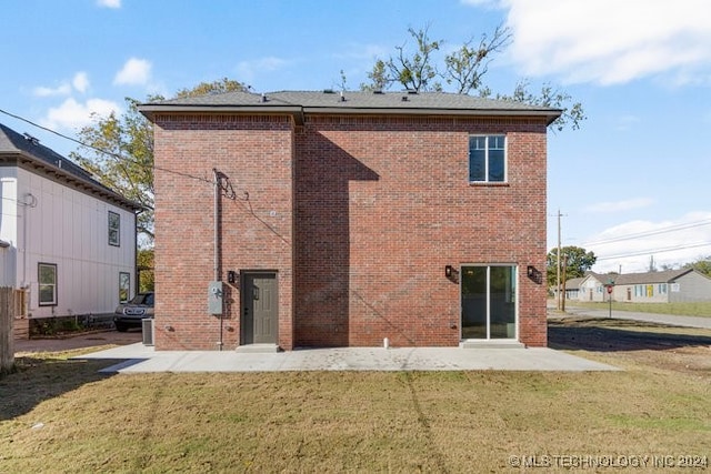 back of property featuring a patio area and a lawn