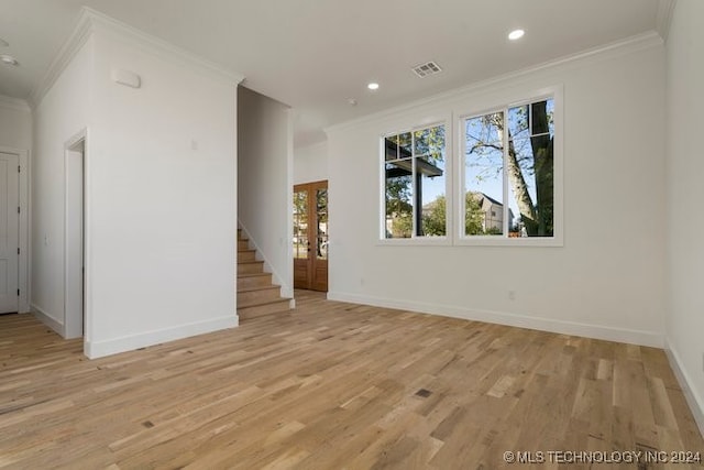 unfurnished living room featuring ornamental molding and light hardwood / wood-style floors