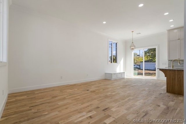 interior space featuring crown molding and light hardwood / wood-style flooring