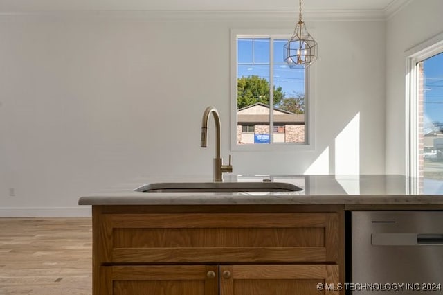 interior space featuring sink, ornamental molding, a chandelier, light wood-type flooring, and dishwasher