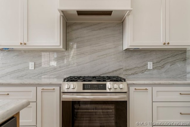 kitchen featuring white cabinetry, high end stainless steel range, tasteful backsplash, and light stone countertops