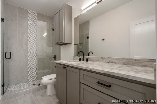 bathroom with vanity, tile patterned floors, toilet, and an enclosed shower