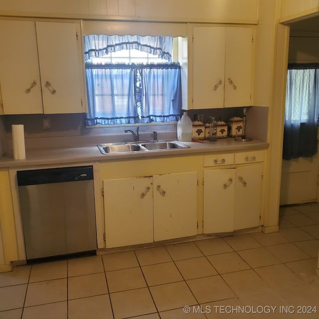 kitchen featuring white cabinetry, stainless steel dishwasher, sink, and light tile patterned flooring