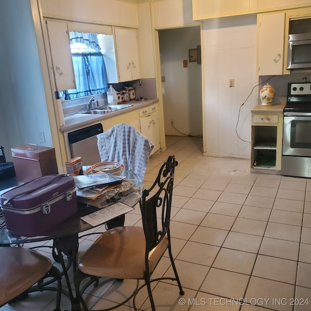 kitchen featuring white cabinets, appliances with stainless steel finishes, sink, and light tile patterned flooring