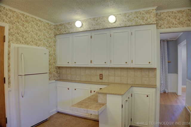 kitchen featuring white fridge, crown molding, light wood-type flooring, a textured ceiling, and white cabinets