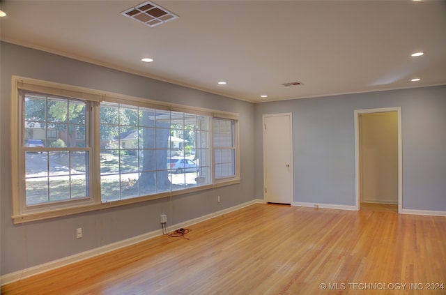 unfurnished room with light hardwood / wood-style flooring and crown molding