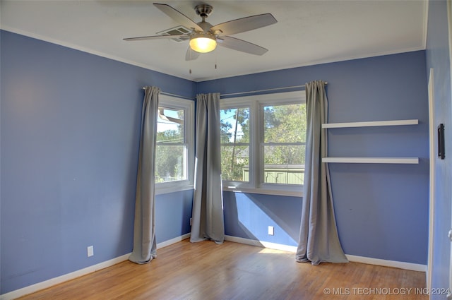 unfurnished room featuring hardwood / wood-style floors, ceiling fan, and crown molding