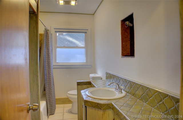 full bathroom featuring toilet, vanity, tile patterned floors, and shower / bathtub combination with curtain