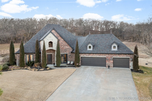 french provincial home with a garage