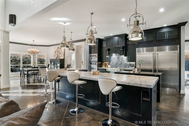 kitchen with built in fridge, a large island, and decorative light fixtures