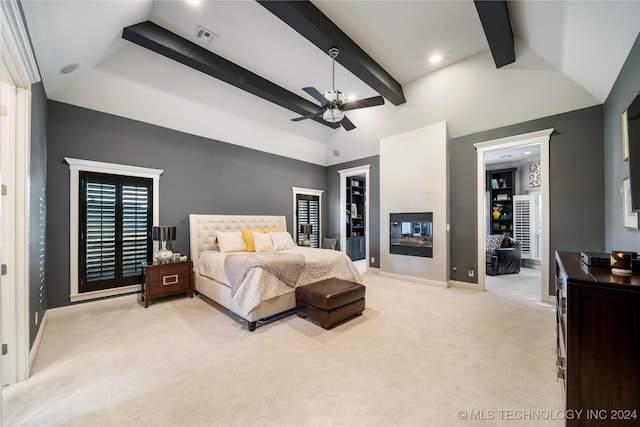 bedroom with vaulted ceiling with beams, light carpet, ceiling fan, a large fireplace, and a spacious closet