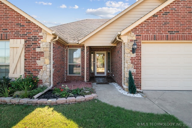 entrance to property with a lawn and a garage