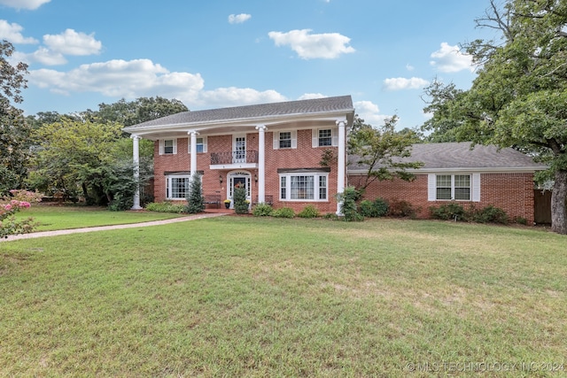 greek revival house featuring a front yard and a balcony