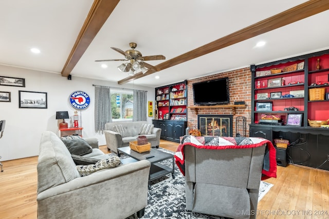 living room featuring crown molding, a fireplace, light hardwood / wood-style floors, beamed ceiling, and ceiling fan