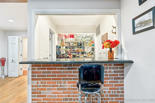 bar featuring wood-type flooring and crown molding