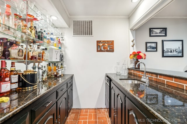 bar featuring dishwasher, sink, ornamental molding, dark brown cabinets, and dark stone countertops