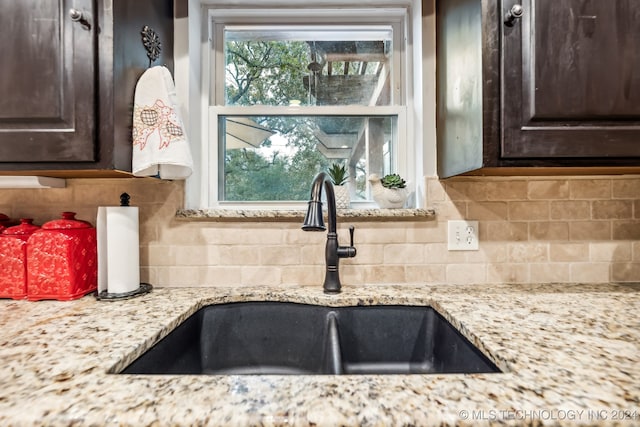 kitchen with dark brown cabinets, sink, and tasteful backsplash