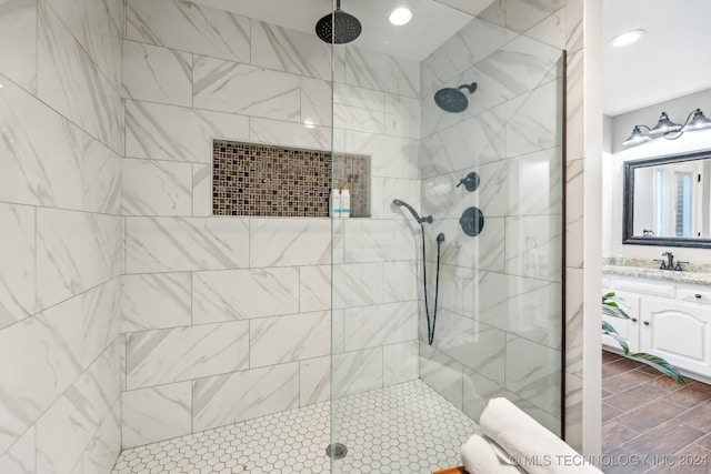 bathroom featuring tiled shower and vanity