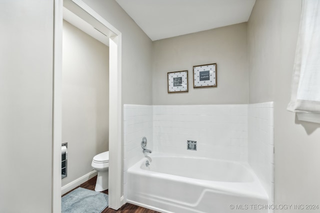 bathroom with a bathtub, hardwood / wood-style flooring, and toilet