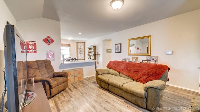 living room featuring light hardwood / wood-style floors and vaulted ceiling