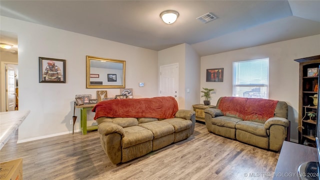 living room featuring hardwood / wood-style floors and vaulted ceiling