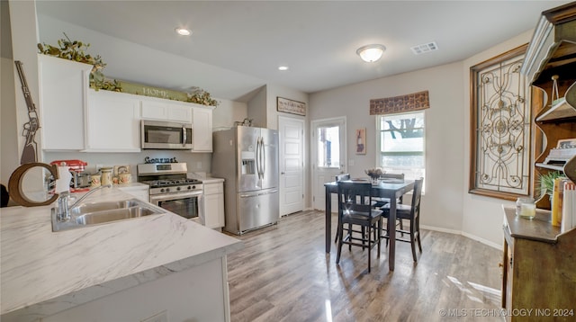 kitchen featuring white cabinetry, sink, appliances with stainless steel finishes, and light hardwood / wood-style flooring