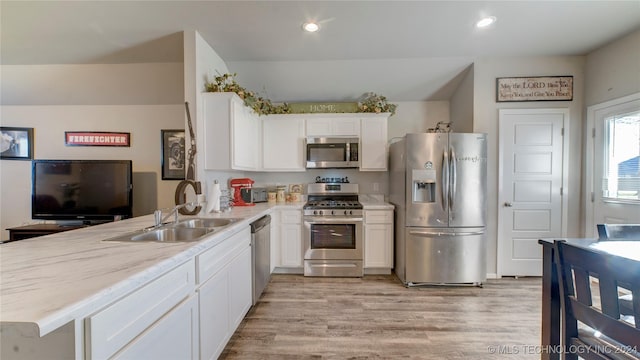 kitchen with white cabinets, kitchen peninsula, sink, and appliances with stainless steel finishes