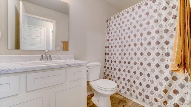 bathroom featuring vanity, toilet, wood-type flooring, and walk in shower