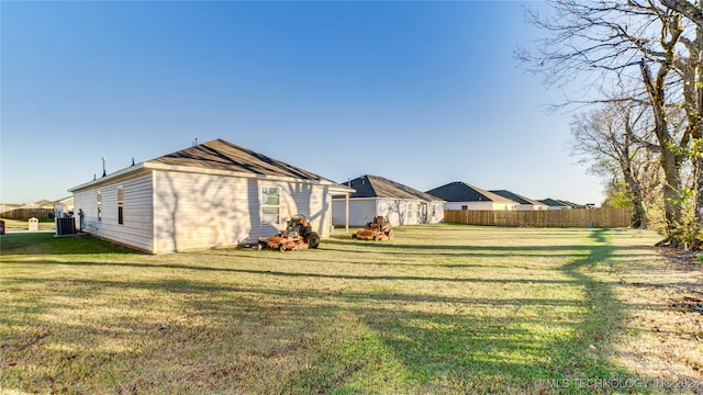 exterior space with central AC and a lawn