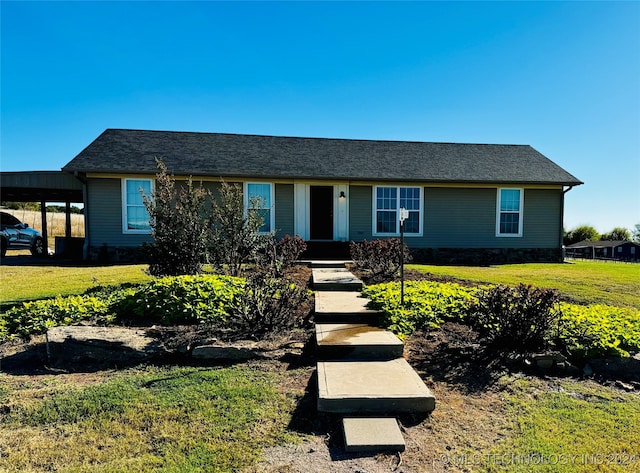 ranch-style home with a carport and a front lawn