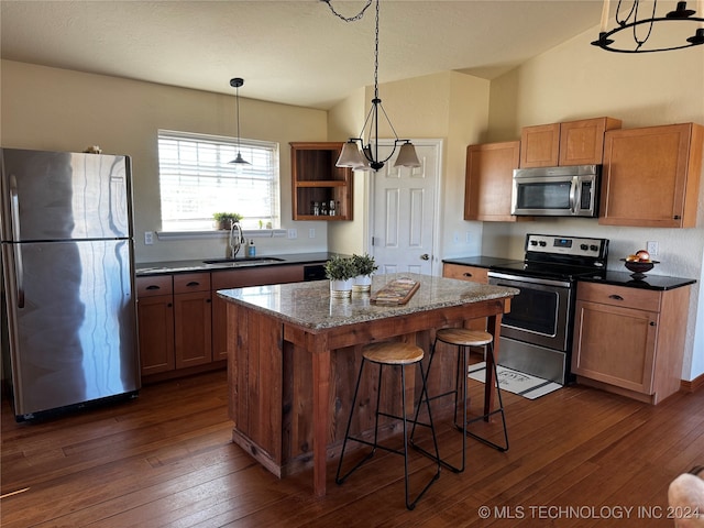 kitchen featuring sink, a kitchen breakfast bar, dark hardwood / wood-style flooring, a kitchen island, and appliances with stainless steel finishes