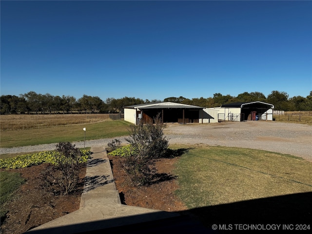 view of yard with a rural view and an outdoor structure