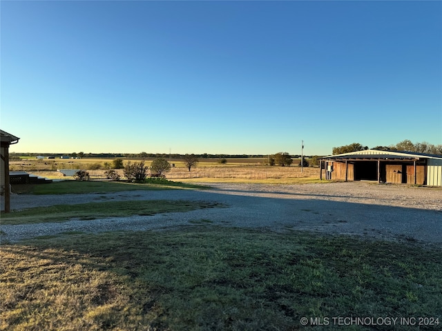 view of yard featuring a rural view and an outdoor structure