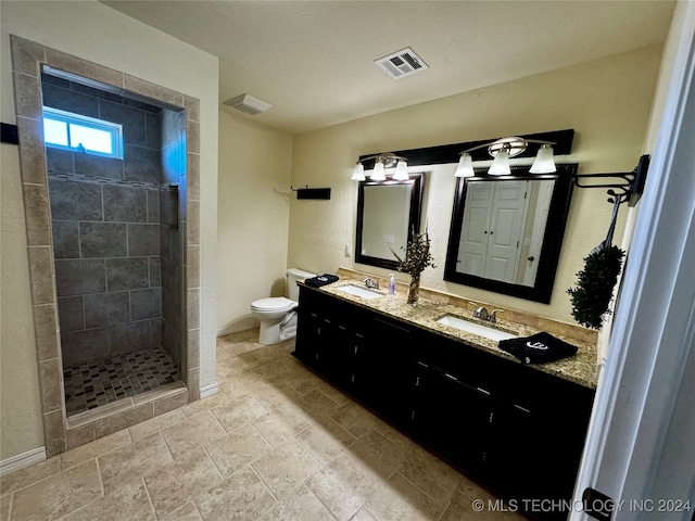 bathroom featuring vanity, toilet, and tiled shower