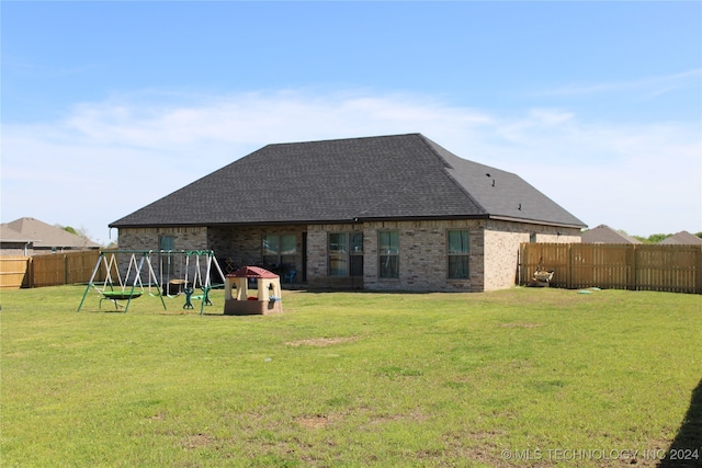 rear view of house with a playground and a lawn