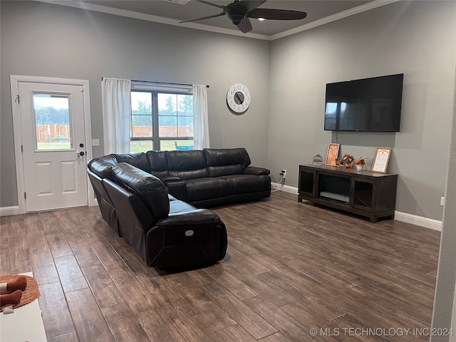 living room with dark wood-type flooring, ceiling fan, a healthy amount of sunlight, and ornamental molding