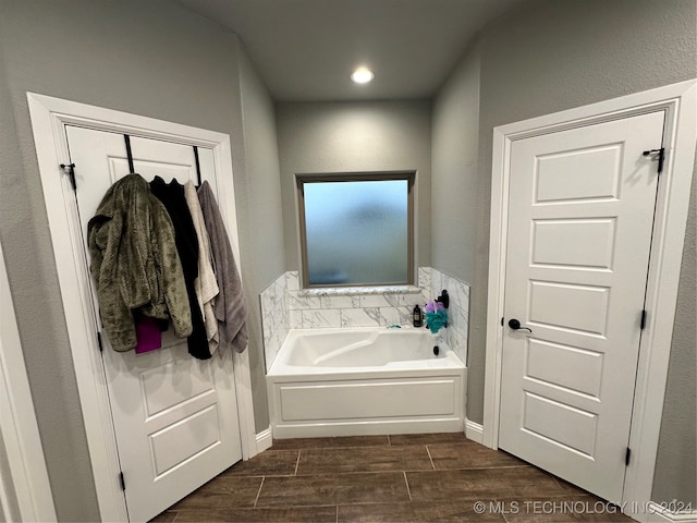 bathroom featuring hardwood / wood-style floors and a bath