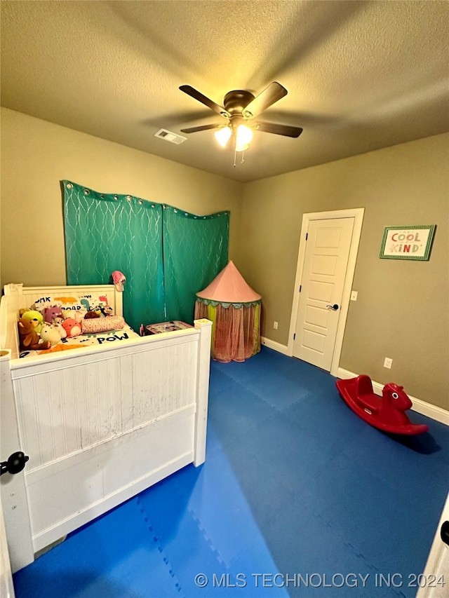 carpeted bedroom with a textured ceiling and ceiling fan