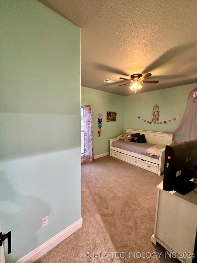 bedroom with a textured ceiling, light carpet, and ceiling fan