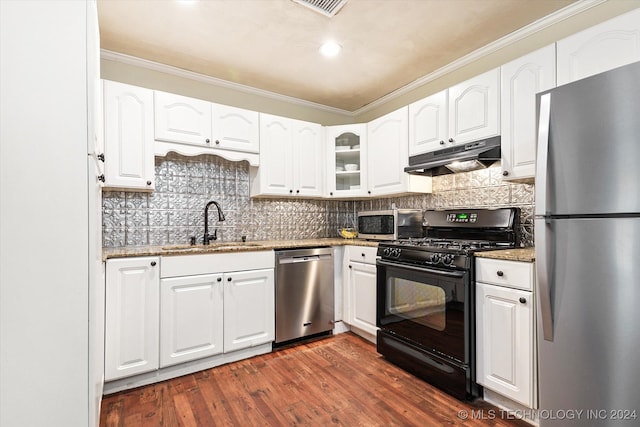 kitchen with white cabinetry, light stone counters, appliances with stainless steel finishes, ornamental molding, and dark hardwood / wood-style flooring