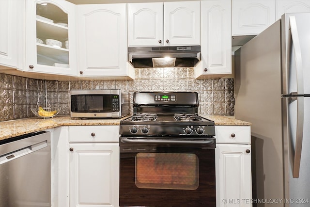 kitchen featuring white cabinets, light stone countertops, decorative backsplash, and appliances with stainless steel finishes