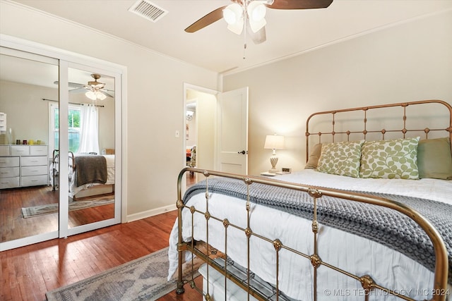 bedroom with ceiling fan, dark hardwood / wood-style floors, a closet, and crown molding