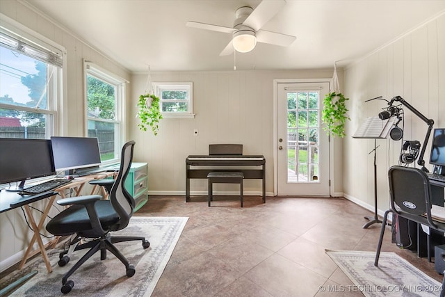 office space with wooden walls, ceiling fan, and crown molding