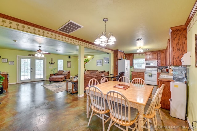 dining room featuring ceiling fan with notable chandelier and french doors